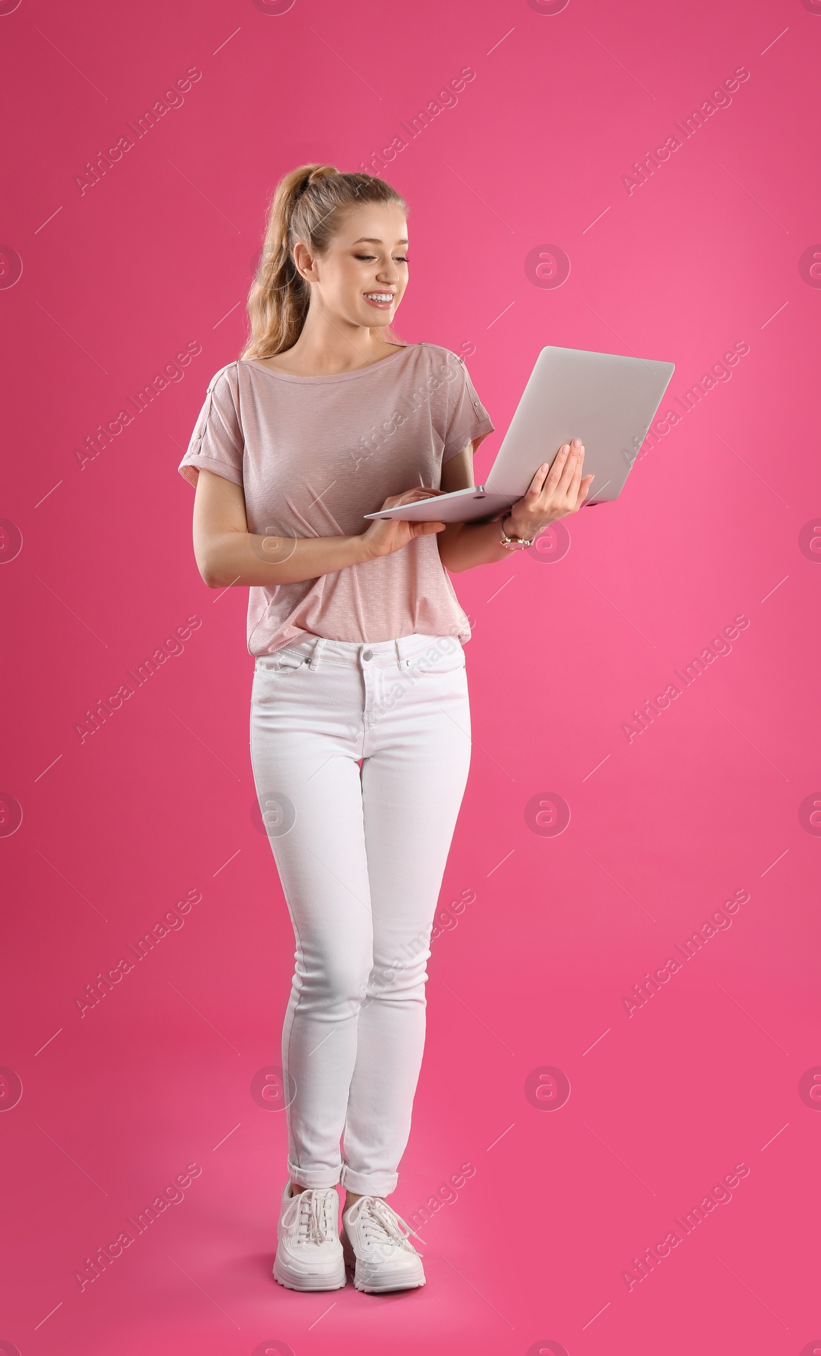 Photo of Full length portrait of young woman with laptop on pink background