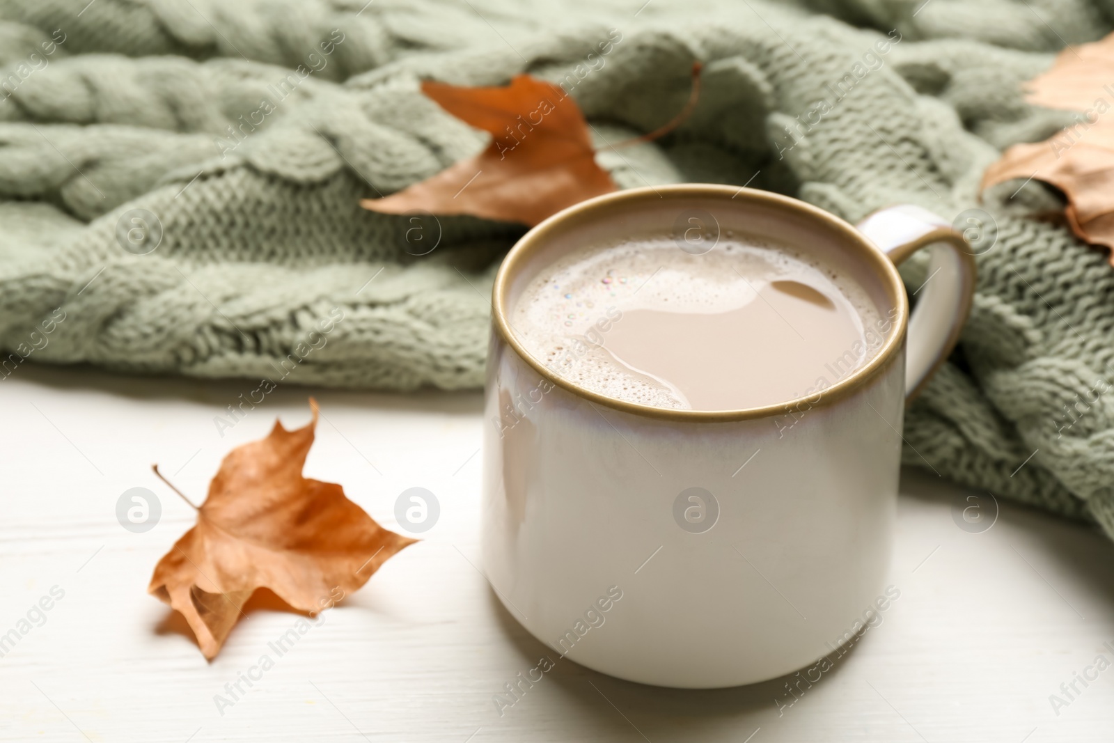 Photo of Composition with coffee and warm plaid on white wooden table, closeup