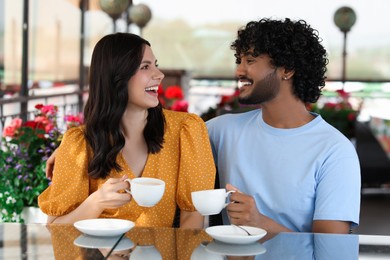 Photo of International dating. Happy couple enjoying tasty coffee in cafe