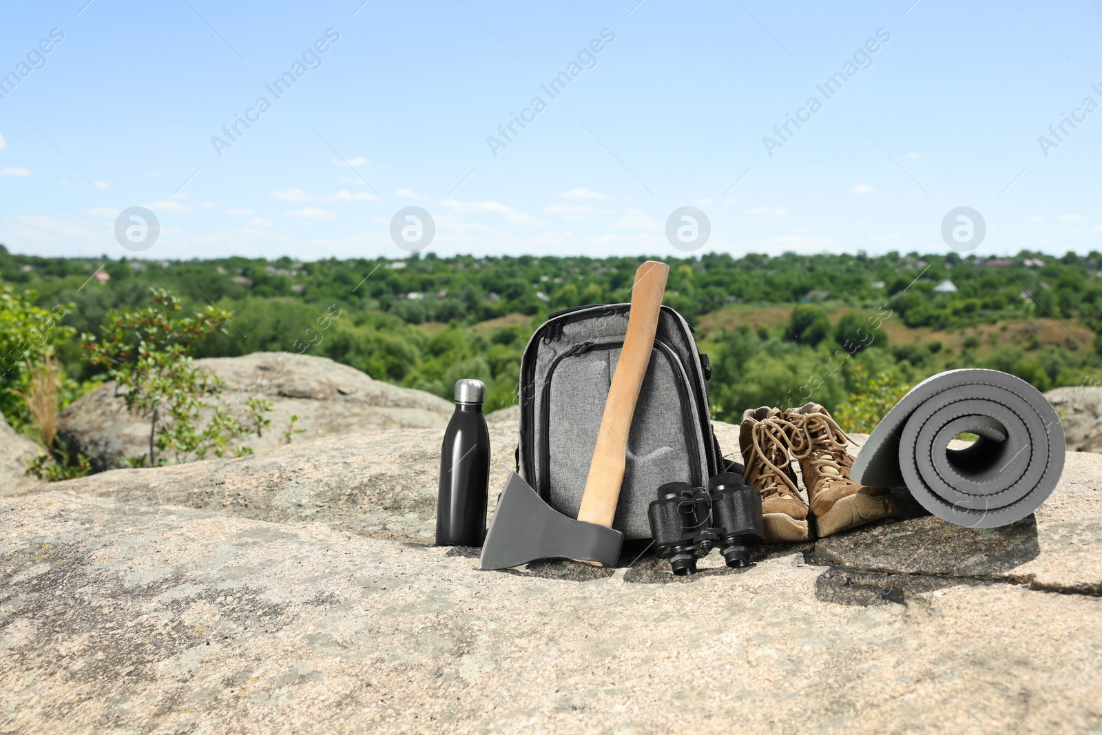 Photo of Set of camping equipment on rock outdoors, space for text