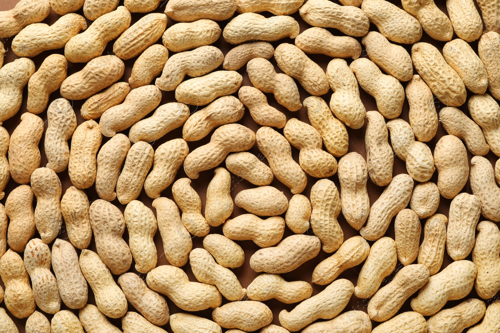 Photo of Many fresh unpeeled peanuts as background, top view