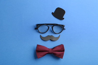 Photo of Flat lay composition with glasses and bow tie on blue background. Happy Father's day
