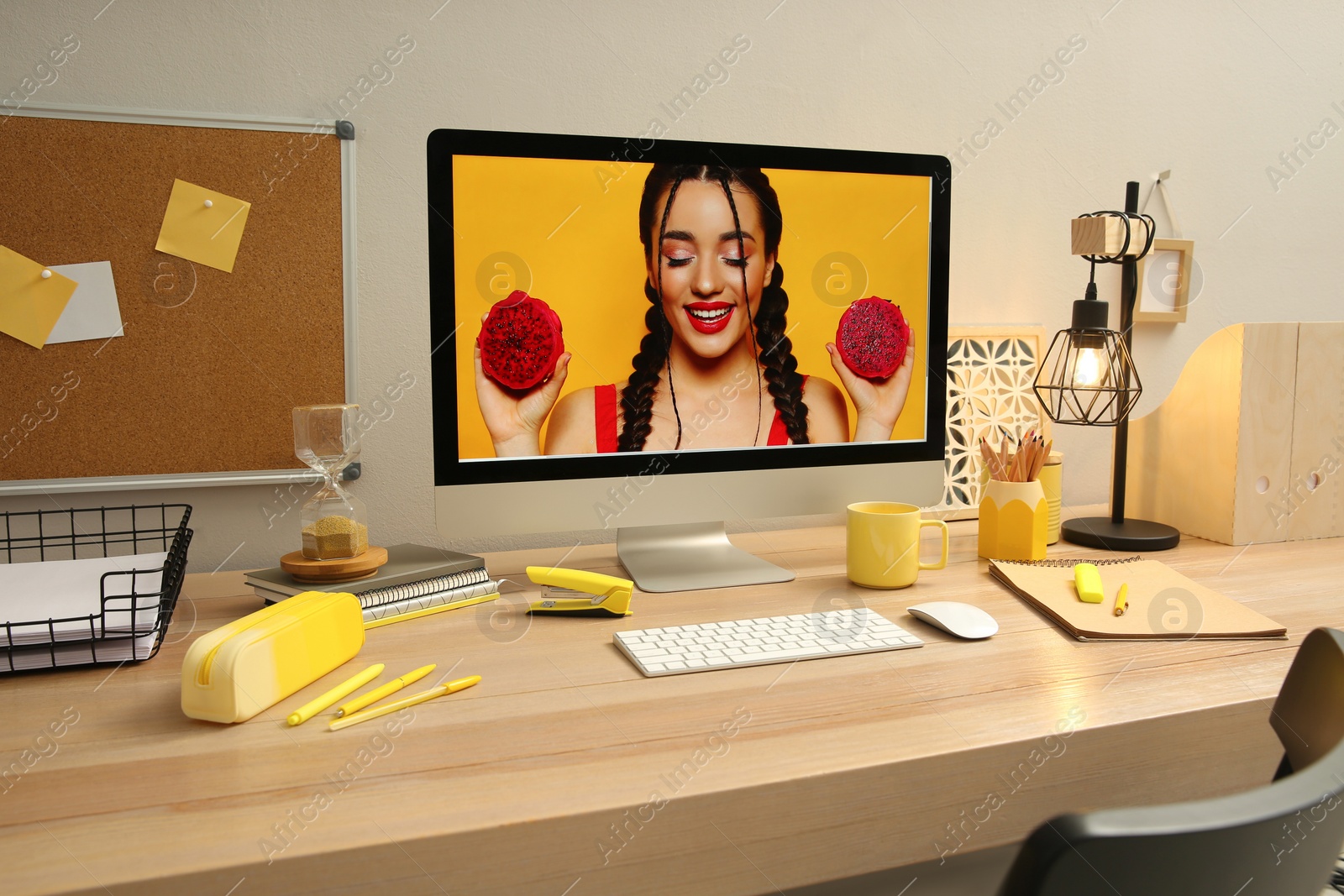 Photo of Stylish workplace with computer on wooden desk near light wall. Interior design