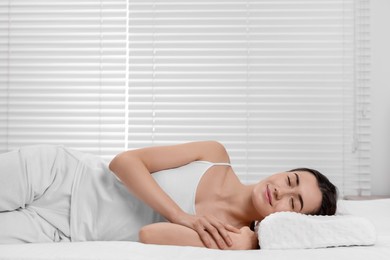 Photo of Woman sleeping on orthopedic pillow at home, space for text