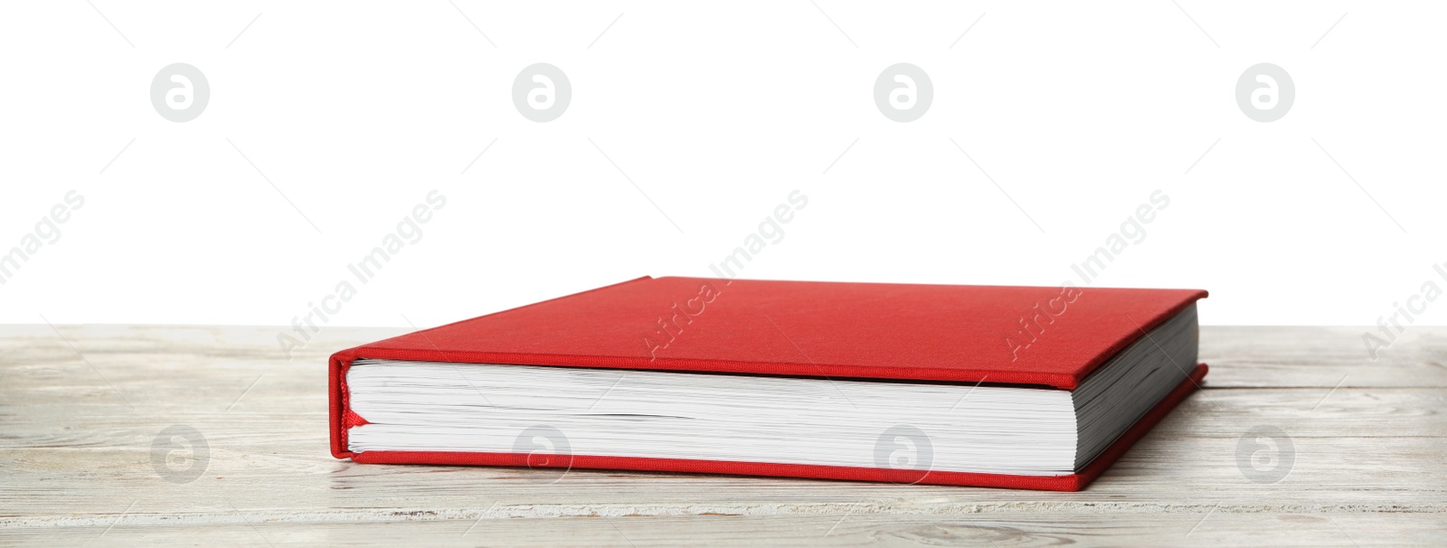 Photo of Book with red cover on wooden table against white background