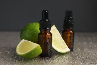 Photo of Bottles of organic cosmetic products and sliced lime on wet surface