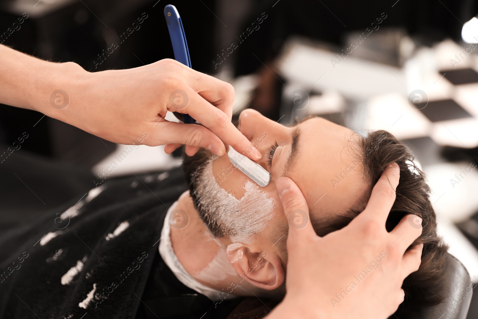 Photo of Professional barber working with client in hairdressing salon. Hipster fashion