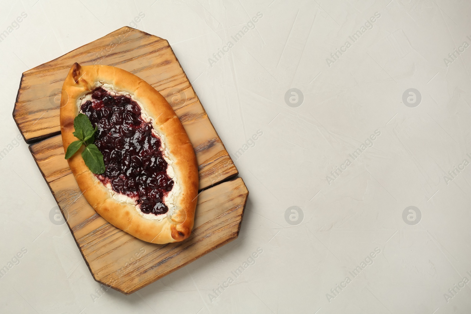Photo of Delicious sweet cottage cheese pastry with cherry jam on light table, top view. Space for text