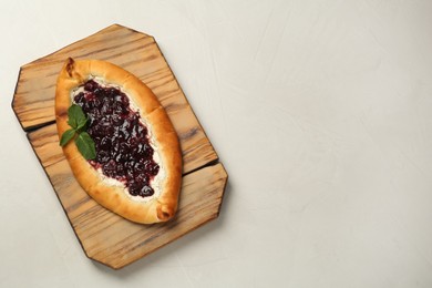 Delicious sweet cottage cheese pastry with cherry jam on light table, top view. Space for text
