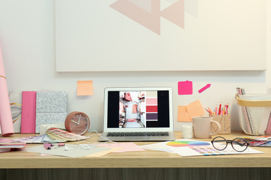 Photo of Designer's workplace with modern laptop and color palettes 