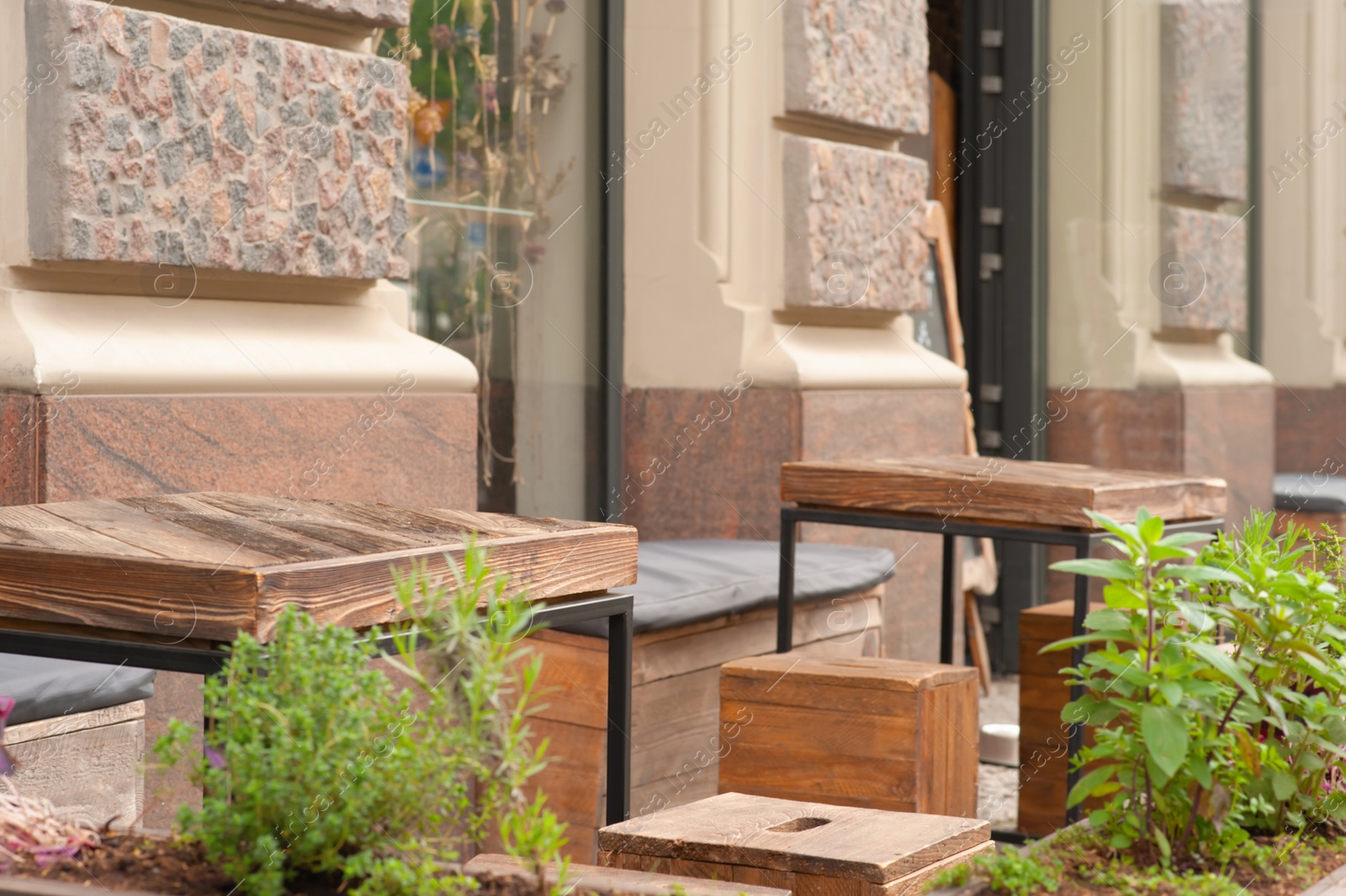 Photo of Wooden stools and tables near cafeteria outdoors