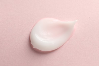 Photo of Sample of face cream on pink background, top view