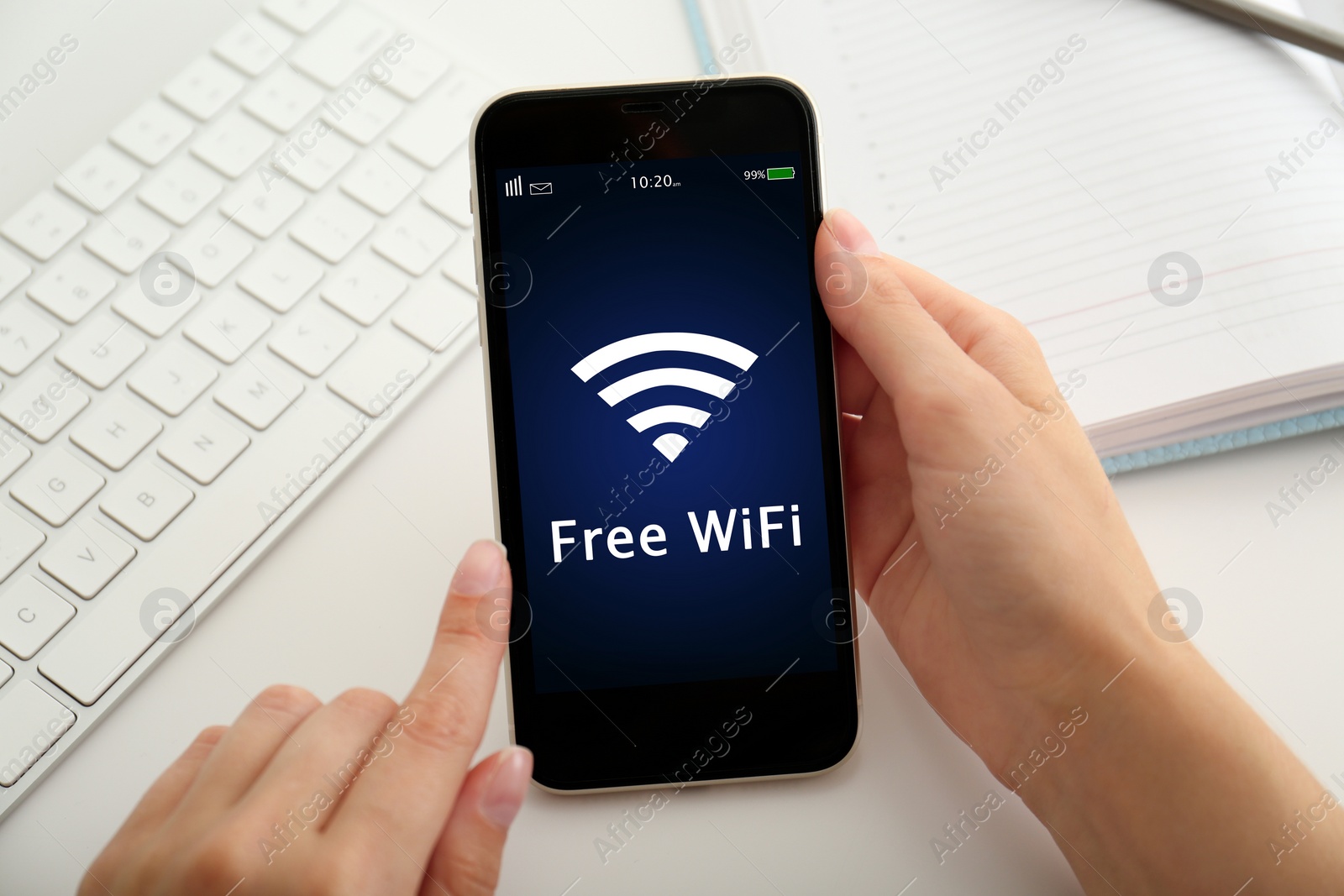 Image of Woman using mobile phone connected to WiFi at table, closeup