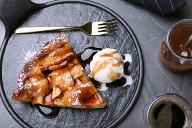 Photo of Slice of traditional apple pie with ice cream served on grey table, flat lay