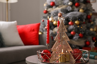 Image of Christmas decor with candles on table in living room. Festive interior