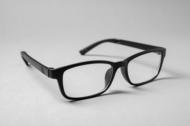 Stylish pair of glasses with black frame on grey background