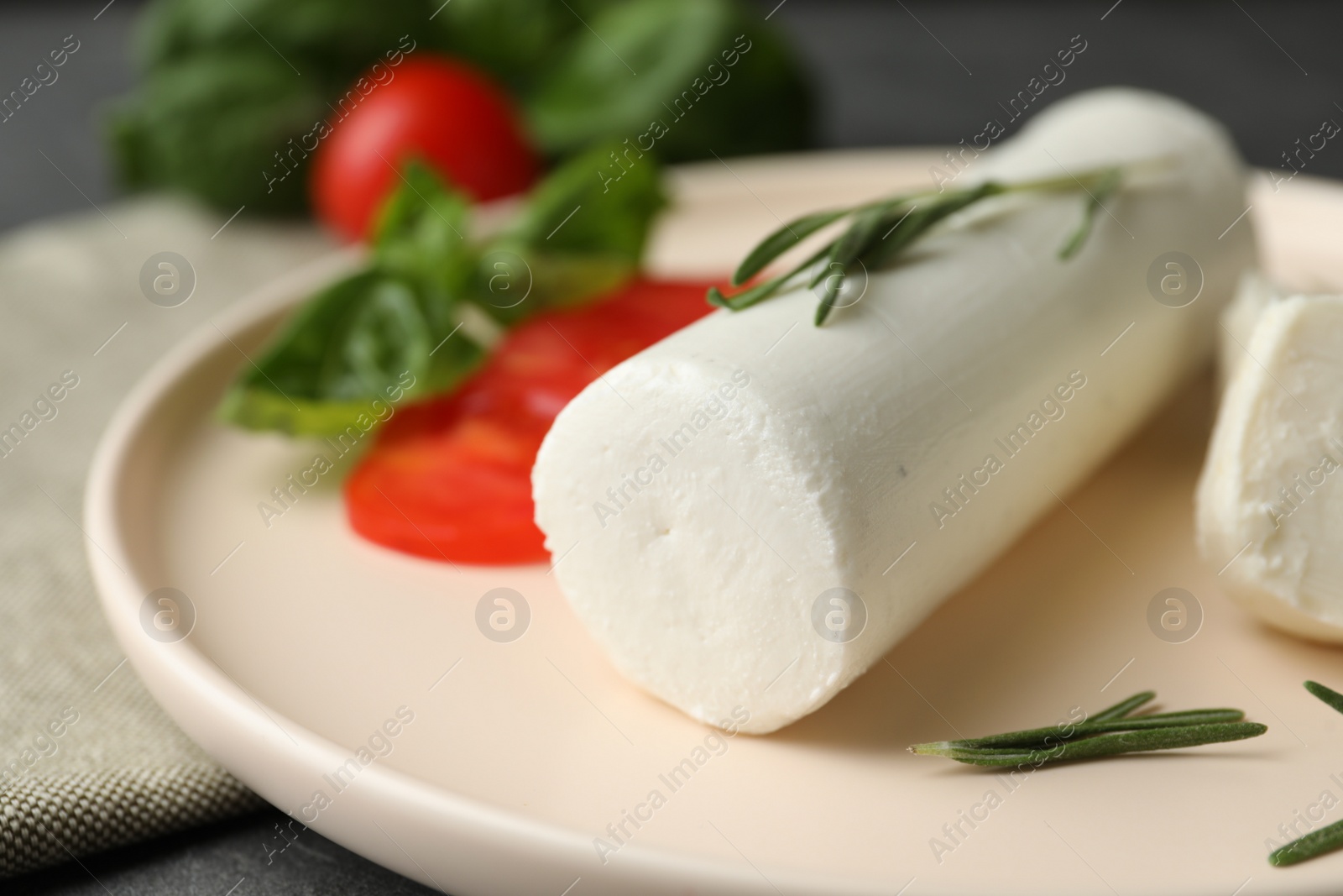 Photo of Delicious goat cheese with rosemary on plate, closeup