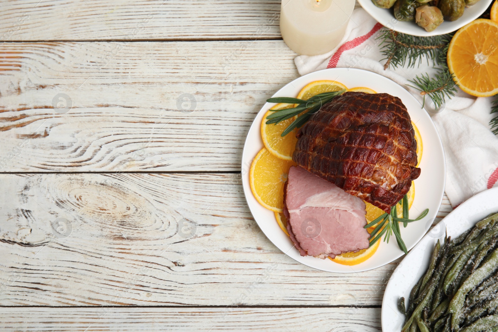 Photo of Flat lay composition with delicious ham and other festive dishes on white wooden table, space for text. Christmas dinner