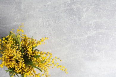 Photo of Bouquet of beautiful mimosa flowers on grey table