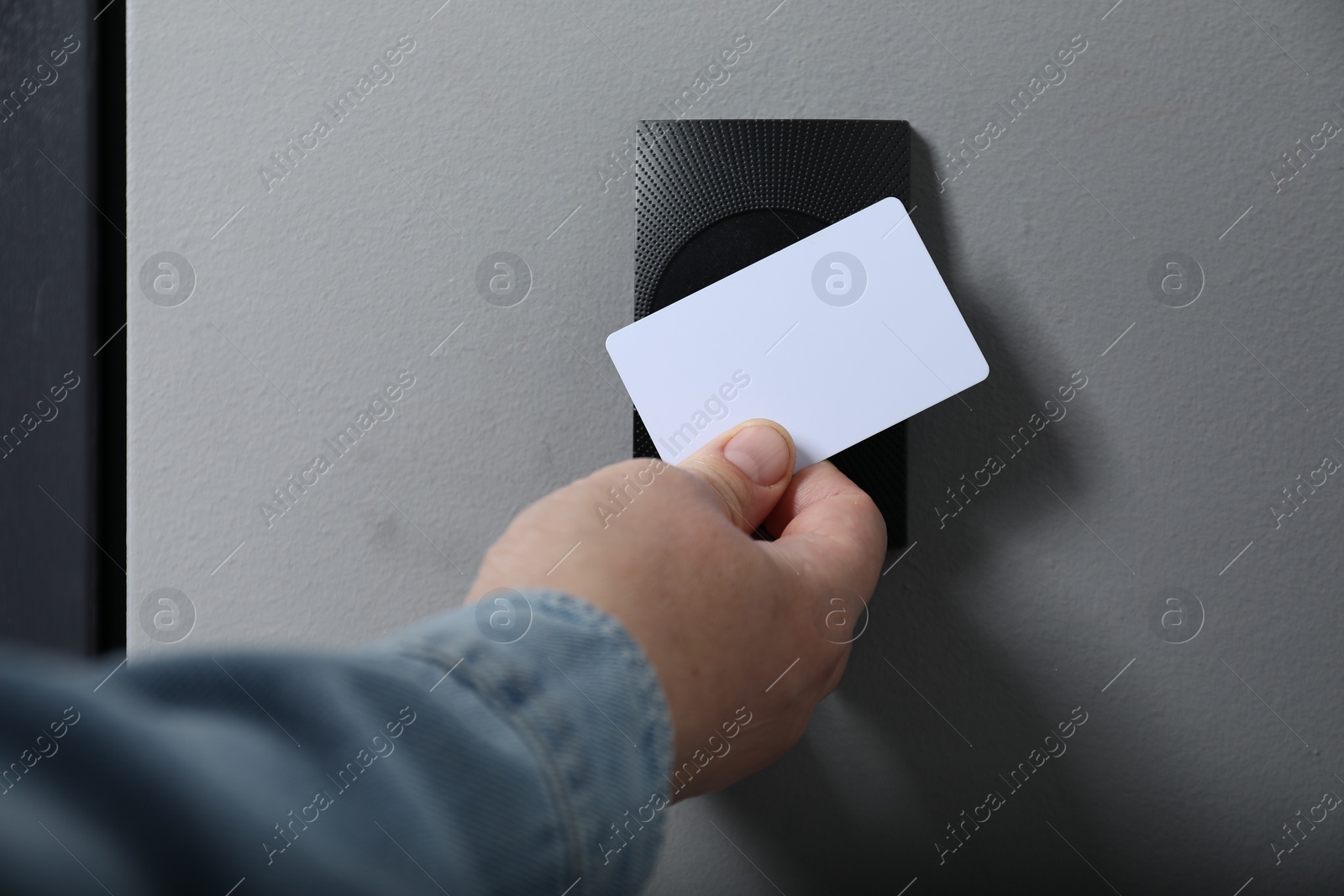 Photo of Man opening magnetic door lock with key card, closeup. Home security