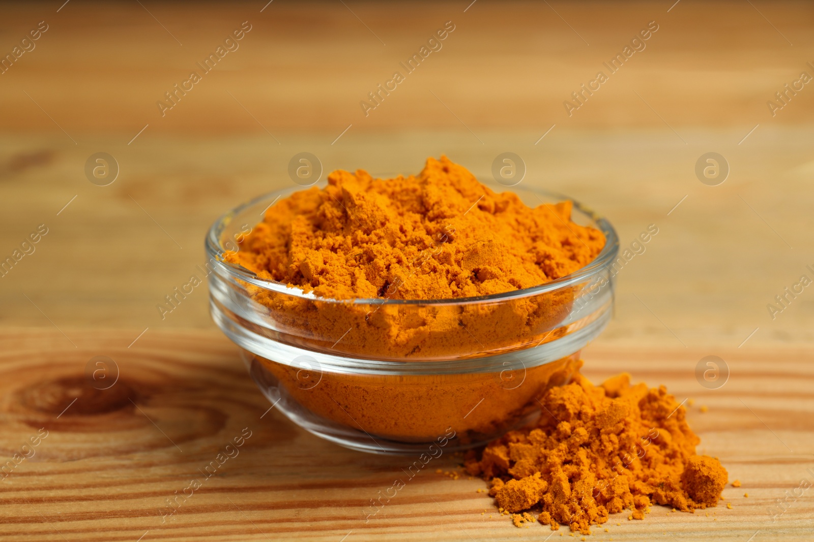 Photo of Aromatic saffron powder in bowl on wooden table