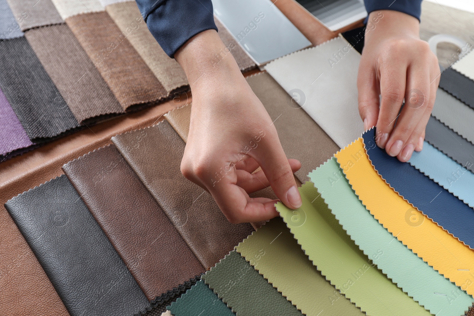 Photo of Young woman choosing among upholstery fabric samples, closeup. Interior design