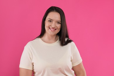 Photo of Beautiful overweight woman with charming smile on pink background