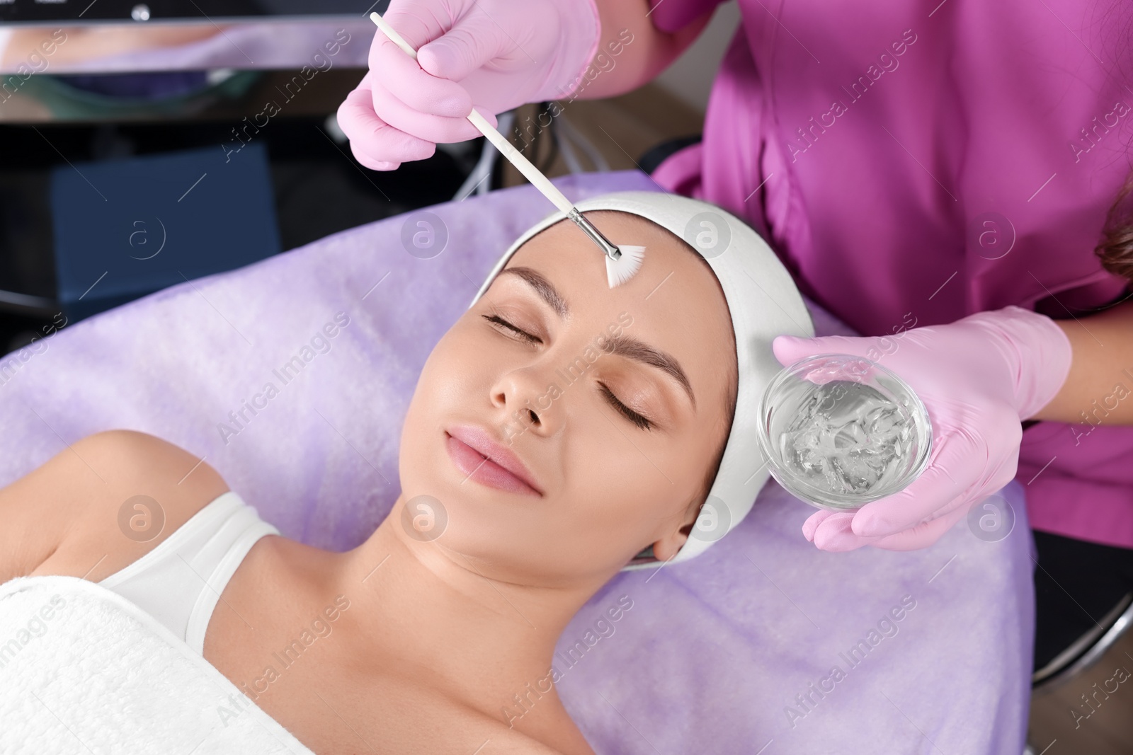 Photo of Young woman undergoing cosmetic procedure in beauty salon