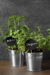 Photo of Aromatic potted melissa and oregano on wooden table