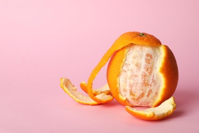 Photo of Cellulite problem. Orange with peels on pink background, space for text