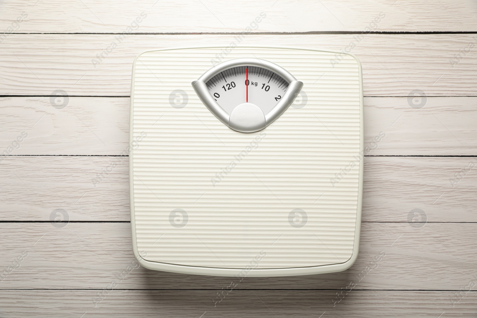 Photo of Weigh scales on white wooden table, top view. Overweight concept