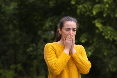 Woman suffering from seasonal spring allergy outdoors