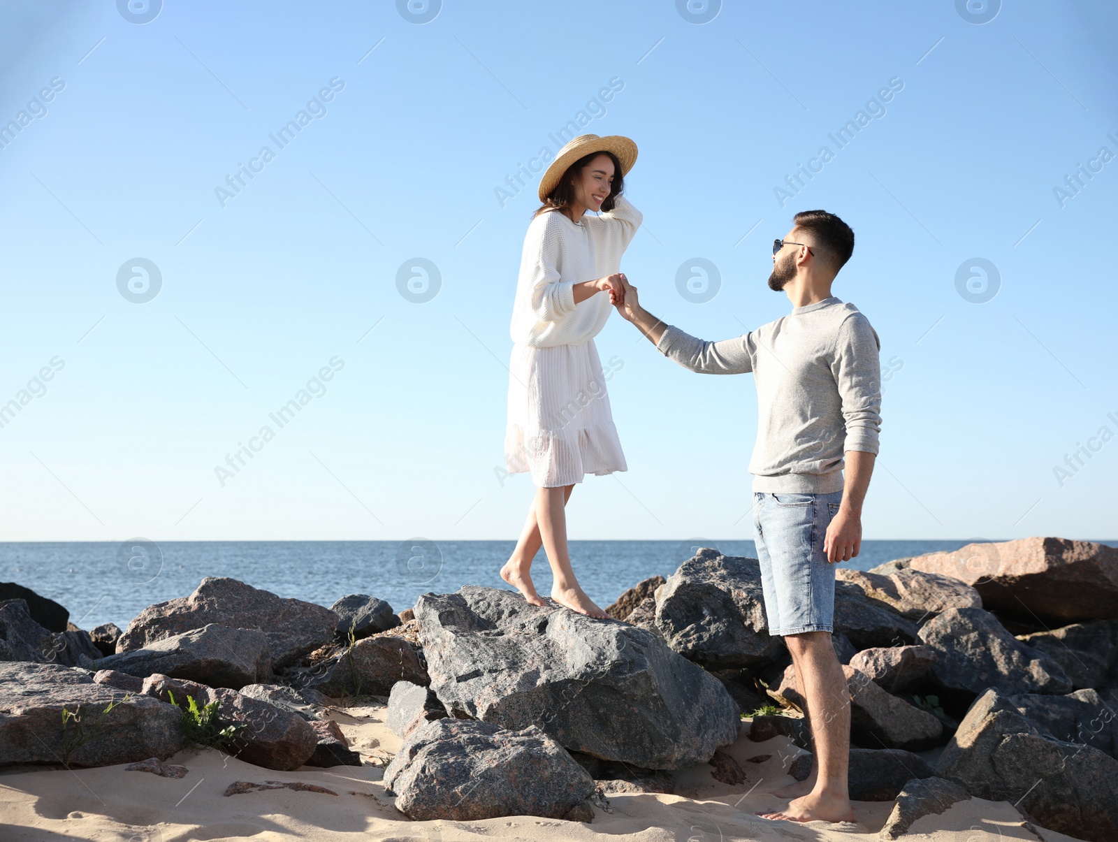 Photo of Happy young couple walking at beach. Honeymoon trip