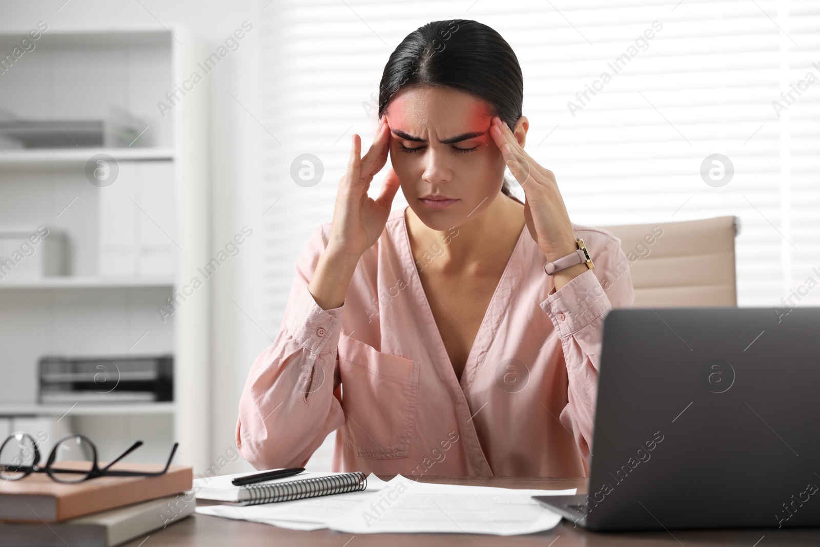 Image of Young woman suffering from headache in office