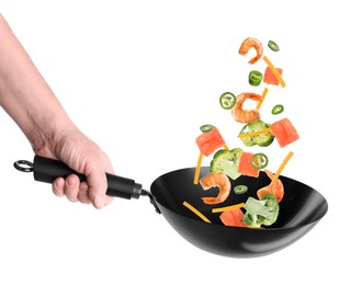 Image of Man tossing ingredients in wok on white background, closeup