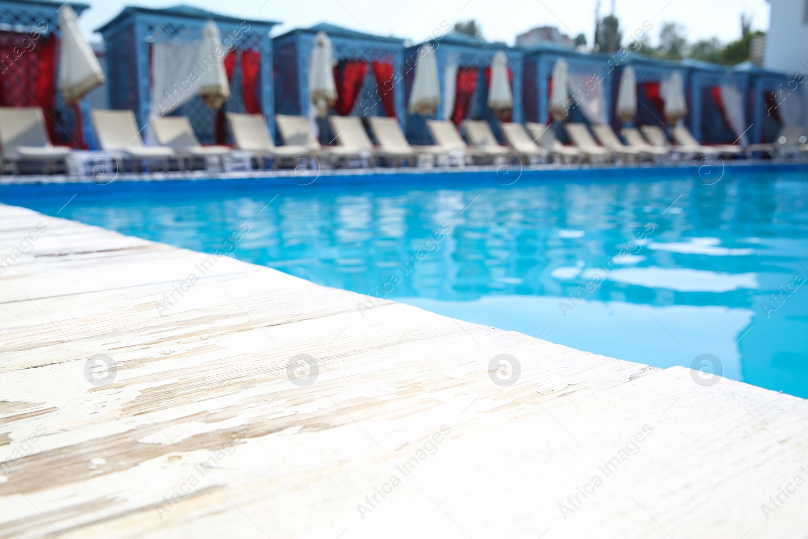Photo of Outdoor swimming pool with sunbeds at resort on sunny day