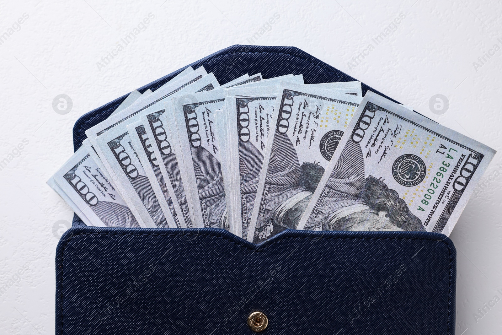 Photo of Dollar banknotes in wallet on white table, top view. Money exchange