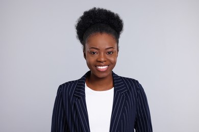 Portrait of beautiful young woman on light grey background