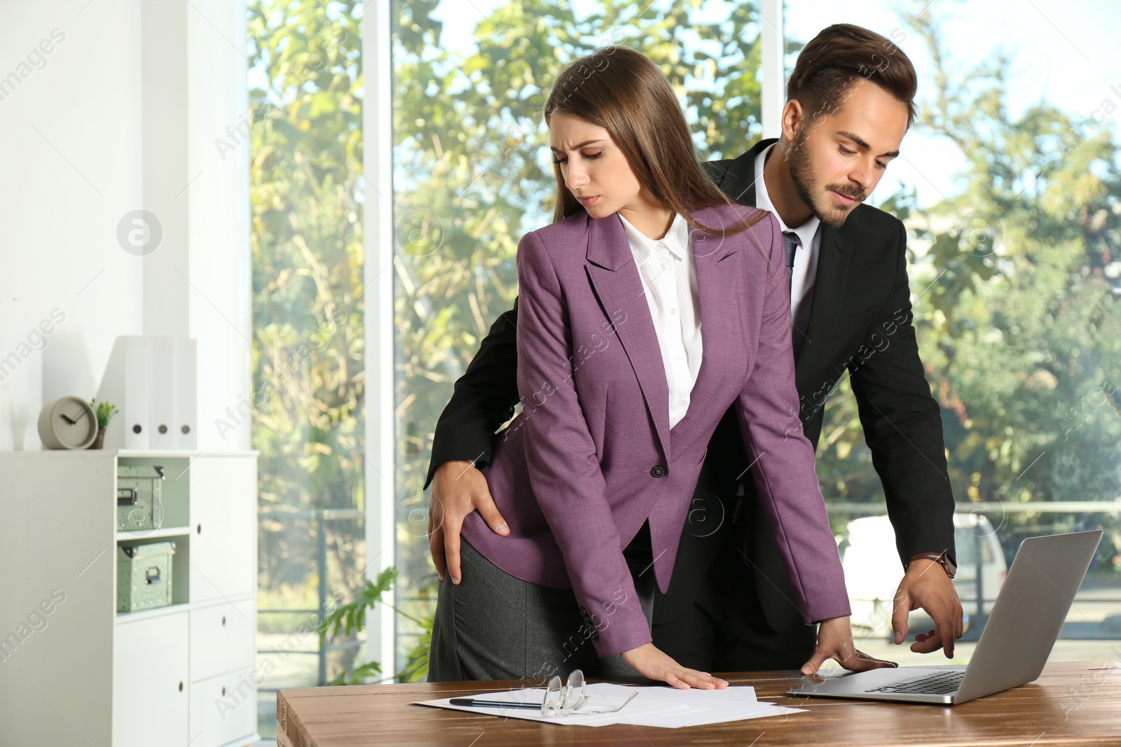 Photo of Boss molesting his female secretary in office. Sexual harassment at work