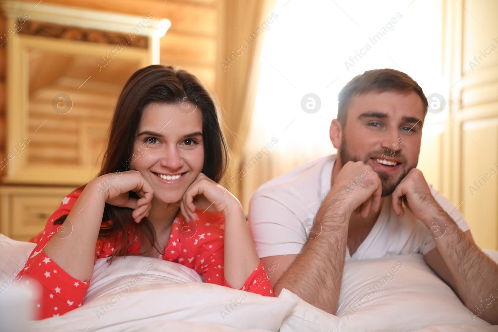 Photo of Couple lying in bed at home. Lazy morning