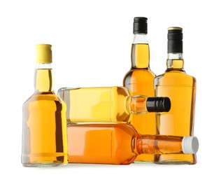 Different sorts of whiskey in glass bottles isolated on white