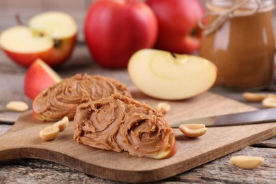 Fresh apples with peanut butter on wooden table, closeup