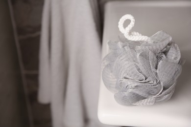 Photo of Grey shower puff on washbasin in bathroom, closeup. Space for text