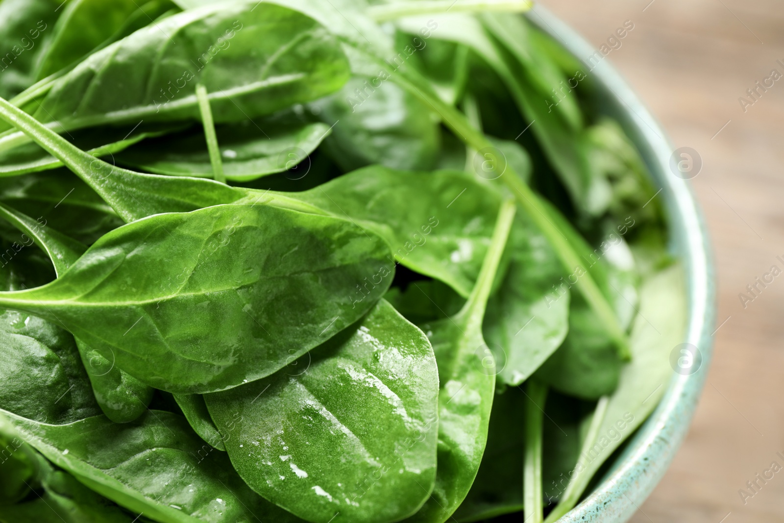 Photo of Fresh green healthy spinach in ceramic bowl, closeup