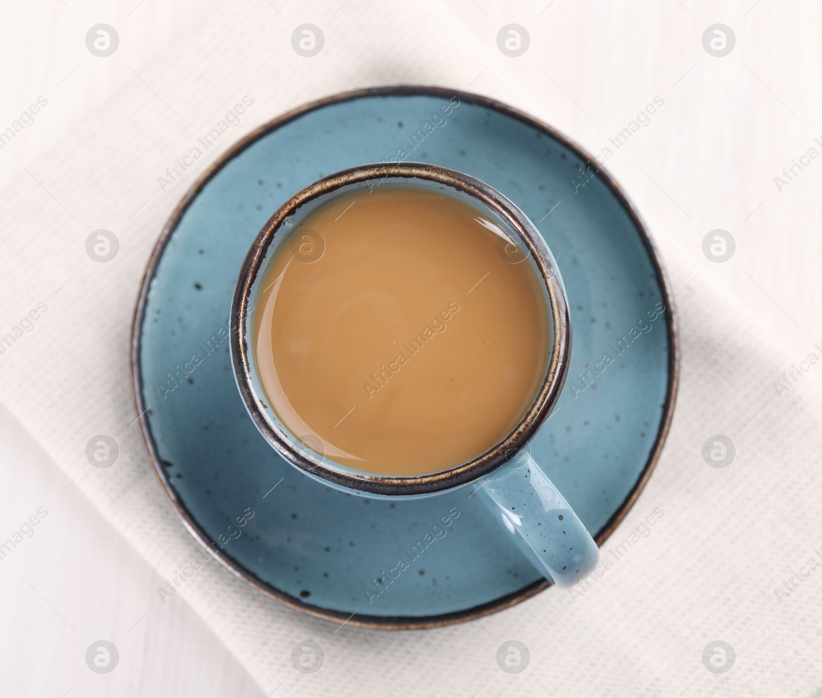 Photo of Delicious coffee in cup on white table, top view