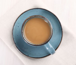 Delicious coffee in cup on white table, top view