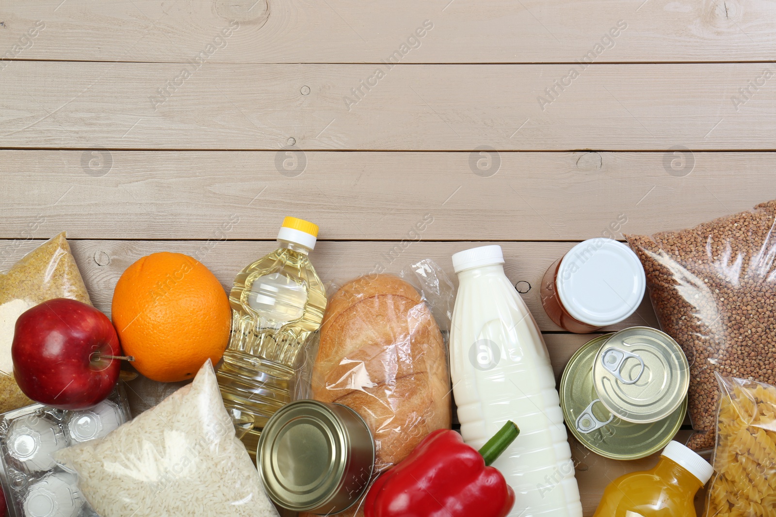 Photo of Different donation food on wooden table, flat lay. Space for text