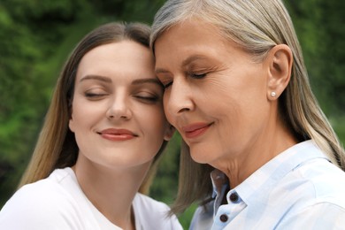 Happy mature mother and her daughter outdoors