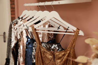 Collection of trendy women's garments on rack indoors, closeup. Clothing rental service