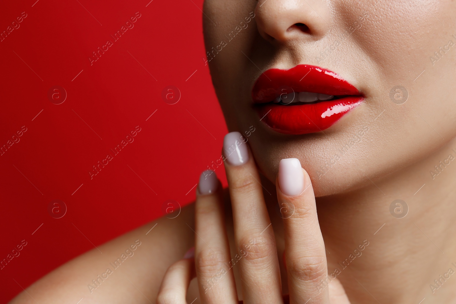 Photo of Closeup view of woman with beautiful lips on red background. Space for text